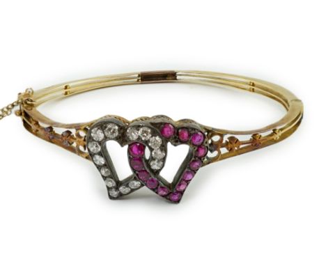 A Victorian pierced 18ct gold, ruby and diamond set twin hearts hinged bangle, interior diameter 57mm, gross weight 13.1 gram