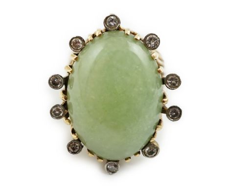 A modern yellow metal and single stone cabochon jade set ring, bordered by ten collet set diamonds, size O, gross weight 20.8