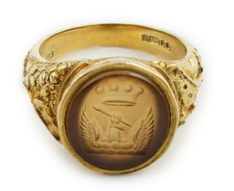 A modern 9ct gold signet ring, with crested intaglio and foliate carved shoulders, size Q, gross weight 7.8 grams.**condition