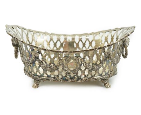 A late Victorian pierced silver oval fruit dish, by Sydney Bellamy Harman, with two ram's head ring handles, on four hoof fee