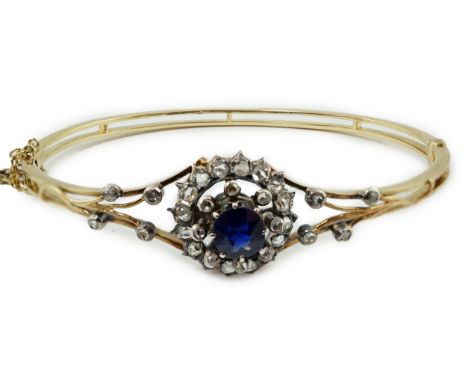 A Victorian gold, sapphire and diamond cluster set hinged bangle, with diamond chip set shoulders, interior diameter 56mm, gr