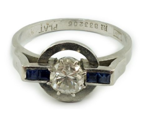 A platinum and single stone diamond set target ring, with four stone square cut sapphire set shoulders, the diamond weighing 