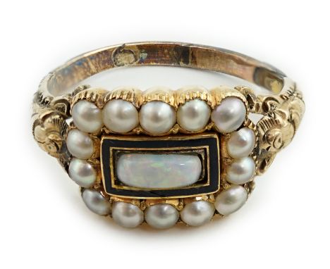 An early Victorian gold, enamel and split pearl mourning ring, the central panel now filled with a white opal, indistinctly e