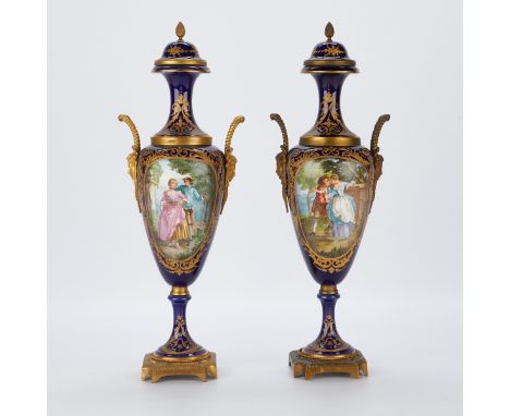 Pair of French old Paris Sevres style porcelain urns. Each with oval reserves depicting two figures in the countryside framed