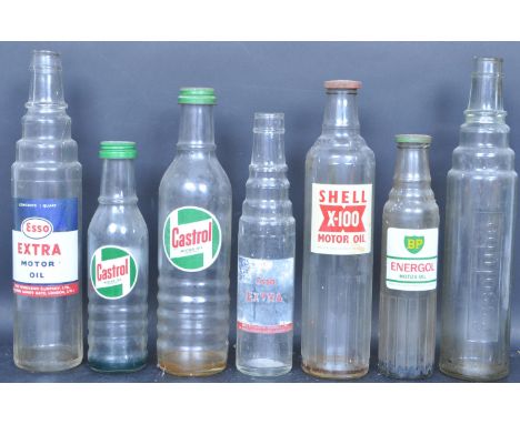 A collection of seven vintage 20th century glass oil bottles comprising of a Castrol Motor Oil, Shell X-100, Esso Lube, BP En
