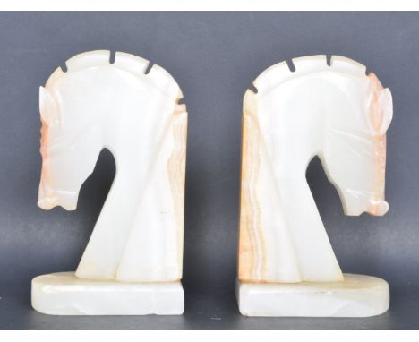 A pair of vintage mid 20th century alabaster L shaped bookends in the form of a horses head raised on a plinth base. Measures