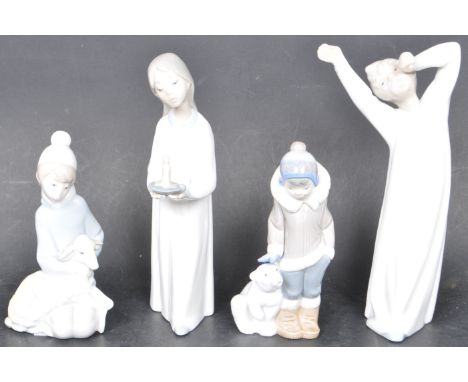 A collection of four vintage 20th century Lladro figurines comprising of a yawning boy, girl holding a candle, boy with a pol