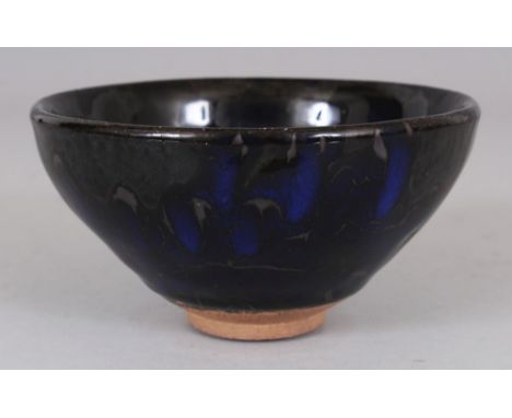 A CHINESE SONG STYLE JAIN WARE GLAZED CERAMIC TEA BOWL, the black lustrous glaze falling short of the foot and incorporating 