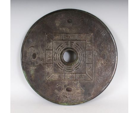A DARK GREEN JADE BI DISC, the disc is carved on both sides with characters and serpents. 12ins diameter.