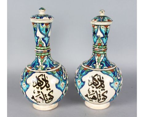 A PAIR OF ISLAMIC BOTTLE VASES AND COVERS with calligraphy. 13ins high.