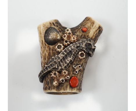 A Japanese coral and mixed metal mounted stag antler netsuke, 19th century, the antler carved in imitation of rocks applied w