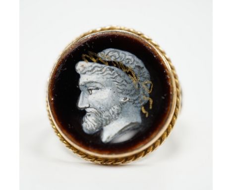 An antique 9ct and enamel set circular ring, depicting the head of a gentleman to dexter, size G, gross weight 3.2 grams.