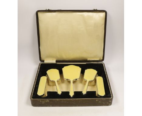 A cased George V silver and yellow guilloche enamel mounted five piece mirror and brush set, Hassett &amp; Harper. Birmingham