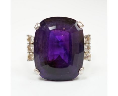 A white metal and single stone cushion cut amethyst set dress ring, with six stone diamond set shoulders, size O, gross weigh