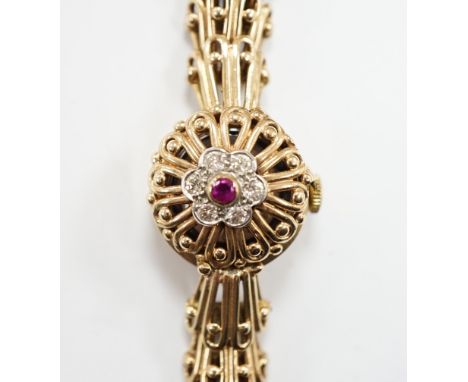A lady's yellow metal manual wind bracelet watch, the dial with ruby and diamond cluster set hinged cover, overall length 16.