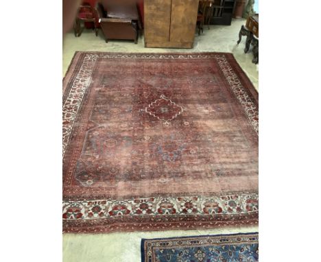 An early 20th century North West Persian red ground carpet, 410 x 348cm, worn and patch repaired.