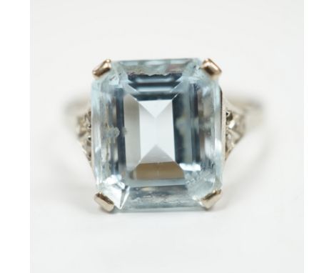 A white metal and single stone emerald cut aquamarine set ring, with rose cut diamond chip set shoulders (one stone missing),