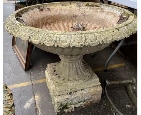 A Large aluminium garden planter urn on a concrete base. 