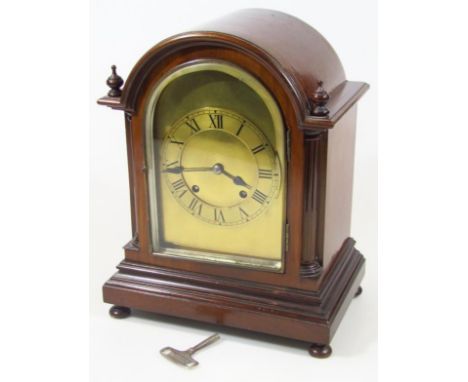An early 20thC mahogany cased dome mantel clock, with 13cm dia. Roman numeric chapter ring before a keywind pendulum swung mo