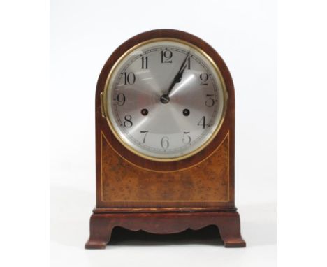 An Edwardian mahogany dome topped mantel clock, with walnut inlay and 13cm dia. Arabic dial revealing a keywind pendulum swun