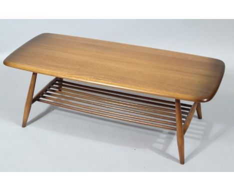 A modern Ercol dark wood coffee table, the oblong top raised on cylindrical supports, 37cm high, 102cm wide, 48cm deep.