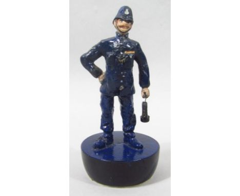 A vintage cast iron doorstop, in the form of a policeman with a lamp and cape.