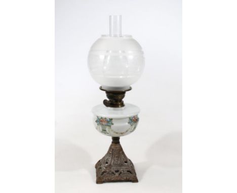 A late Victorian oil lamp, with frosted and clear glass floral orb shade, clear funnel and milk glass reservoir painted with 