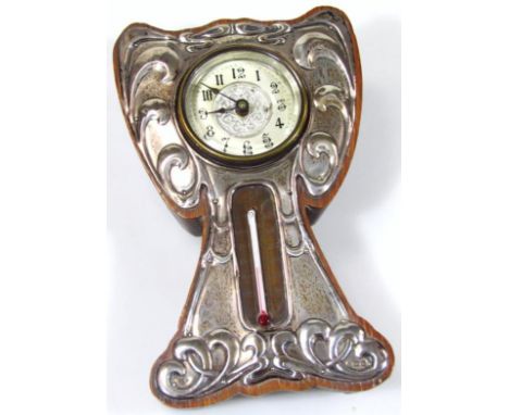 An Edwardian oak and silver Art Nouveau mantel clock, with 4.5cm dia. Arabic dials surrounded by scrolls with thermometer ben