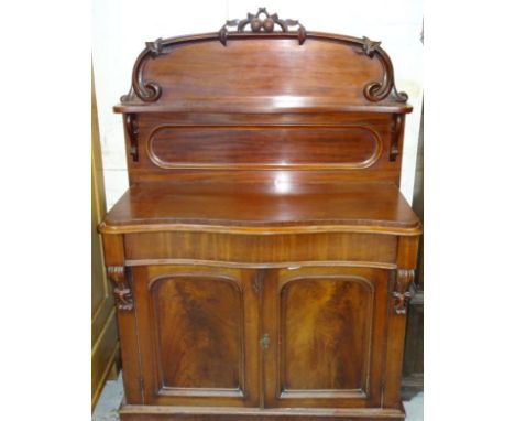 A Victorian mahogany serpentine fronted chiffonier, the carved moulded back raised above a serpentine shelf, cushion drawer a