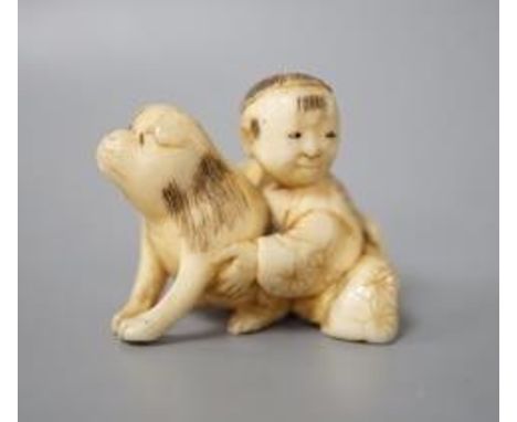 A Japanese ivory netsuke of a boy and puppy, Meiji period, unsigned, 4cm