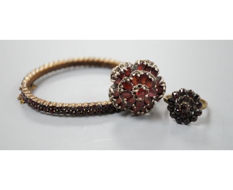 A Victorian garnet cluster set gilt metal dress ring, one other garnet set cluster ring and a garnet paste set hinged bangle.