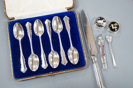 A cased set of six silver teaspoons, a silver bread knife, two 925 pill boxes, an 800 and enamel 'Tutankhamun' pencil case an