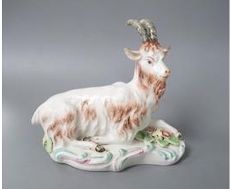 A rare Derby figure of a goat,  naturalistically painted, recumbent on a scroll moulded base, c.1758-60, patch marks 12cm