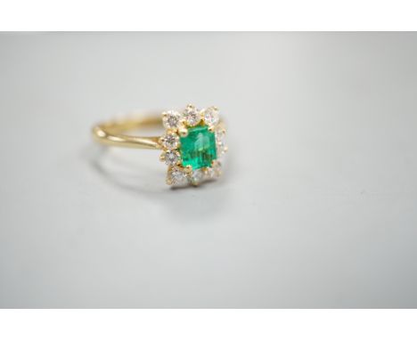 A 750 yellow metal, emerald and diamond set cluster ring, size m, gross weight 3.2 grams.