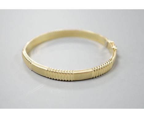 A modern 585 yellow metal hinged bangle, 12.8 grams.