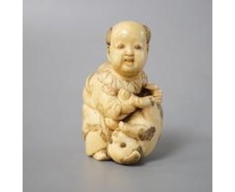 A Japanese ivory netsuke of boy and puppy, Meiji period, signed 4cm