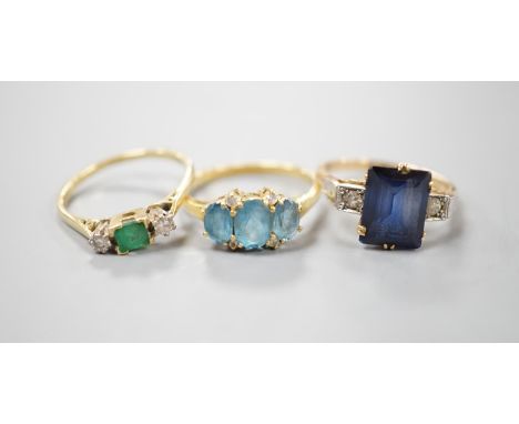 Three assorted 18ct and gem set dress rings, including emerald and diamond three stone, size Q/R, gross 11.7 grams.