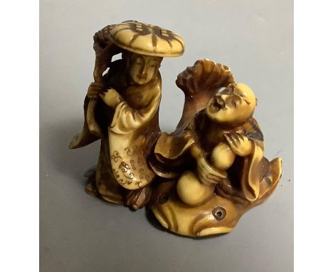 A Japanese stained ivory Netsuke of two figures, signed Masatsugo Kaigyokusai, Meiji period, 3cm high