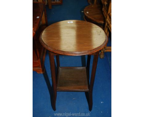 A darkwood circular table with lower shelf.