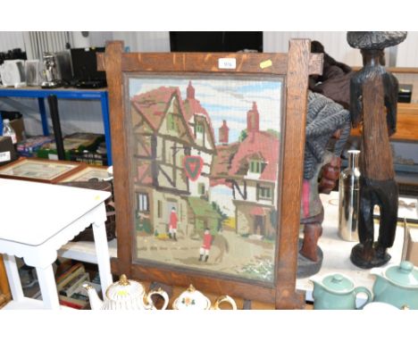 An oak framed wool work fire screen