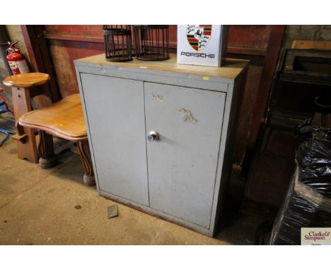 A metal work shop cabinet with internal shelf