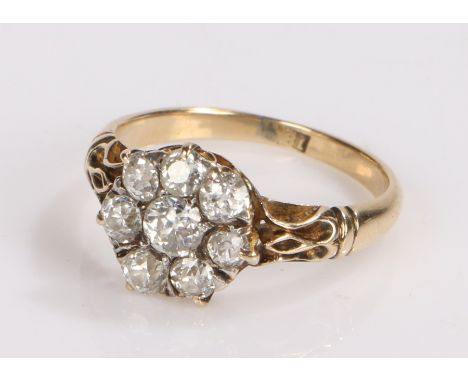 18 carat gold and diamond ring, the central diamond surrounded by a further seven diamonds in a flower head formation, ring s