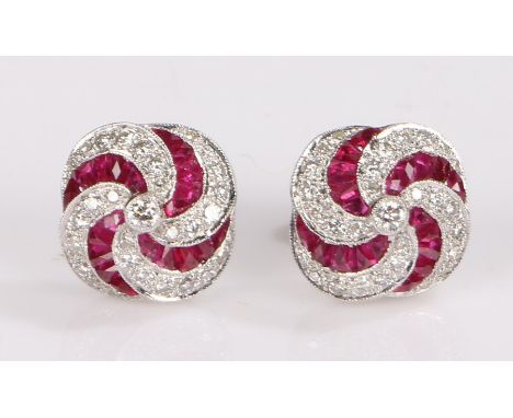 Pair of 18 carat white gold ruby and diamond set earrings, the studs set with a curved ruby and diamond design, 12mm diameter