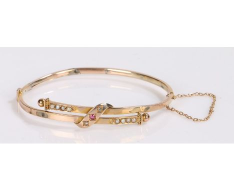 Ruby and pearl set bracelet, with a central ruby and pearls to the arms, 65mm diameter, 4.7 grams