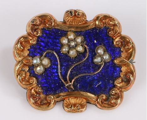 19th Century mourning brooch, with pearl set flowers on an enamel back and scroll frame, locket to the back, 37mm diameter 