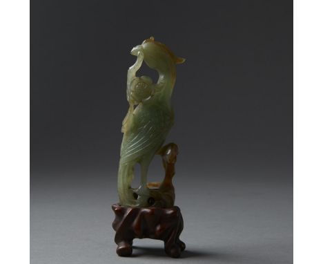 A stunning semi-translucent jade with a very finely carved phoenix. All mounted on a well carved wooden stand. Dimensions: 4 