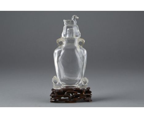 A fine Chinese carved rock crystal vase and cover with several accompanying animals. The grouping stands on a period wooden s