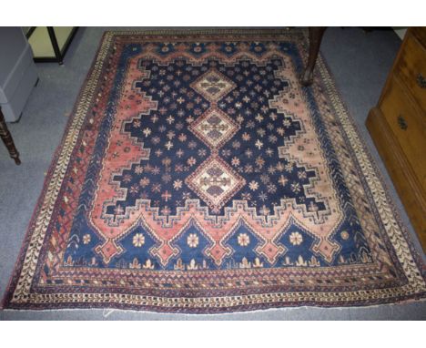 An Eastern carpet, the three central medallions on a blue ground within a multi-field border, 243 x 186cm