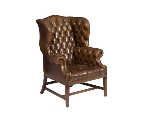 A Georgian button upholstered leather wing back armchair, on square tapering front legs/see illustration