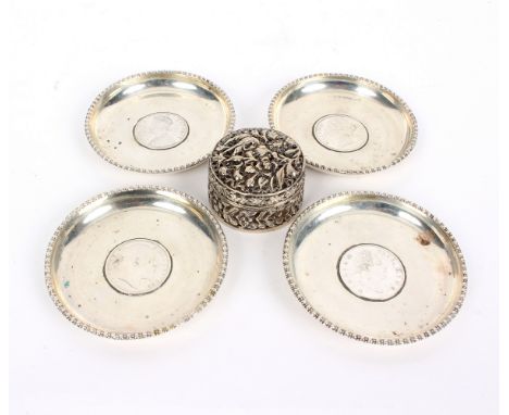 Four Indian silver ashtrays, each set with a one Rupee coin (1835, 1840, 1901 and 1907) and with beaded border, 8cm diameter 